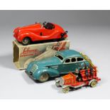 A Shuko "Examico 4001" tinplate clockwork car in red with steering to front wheels, with key (