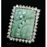 A modern silvery coloured metal mounted nephrite and diamond set dress ring, the oblong pale green