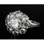 An 18ct white gold all diamond set flowerhead pattern ring, the central old cut stone