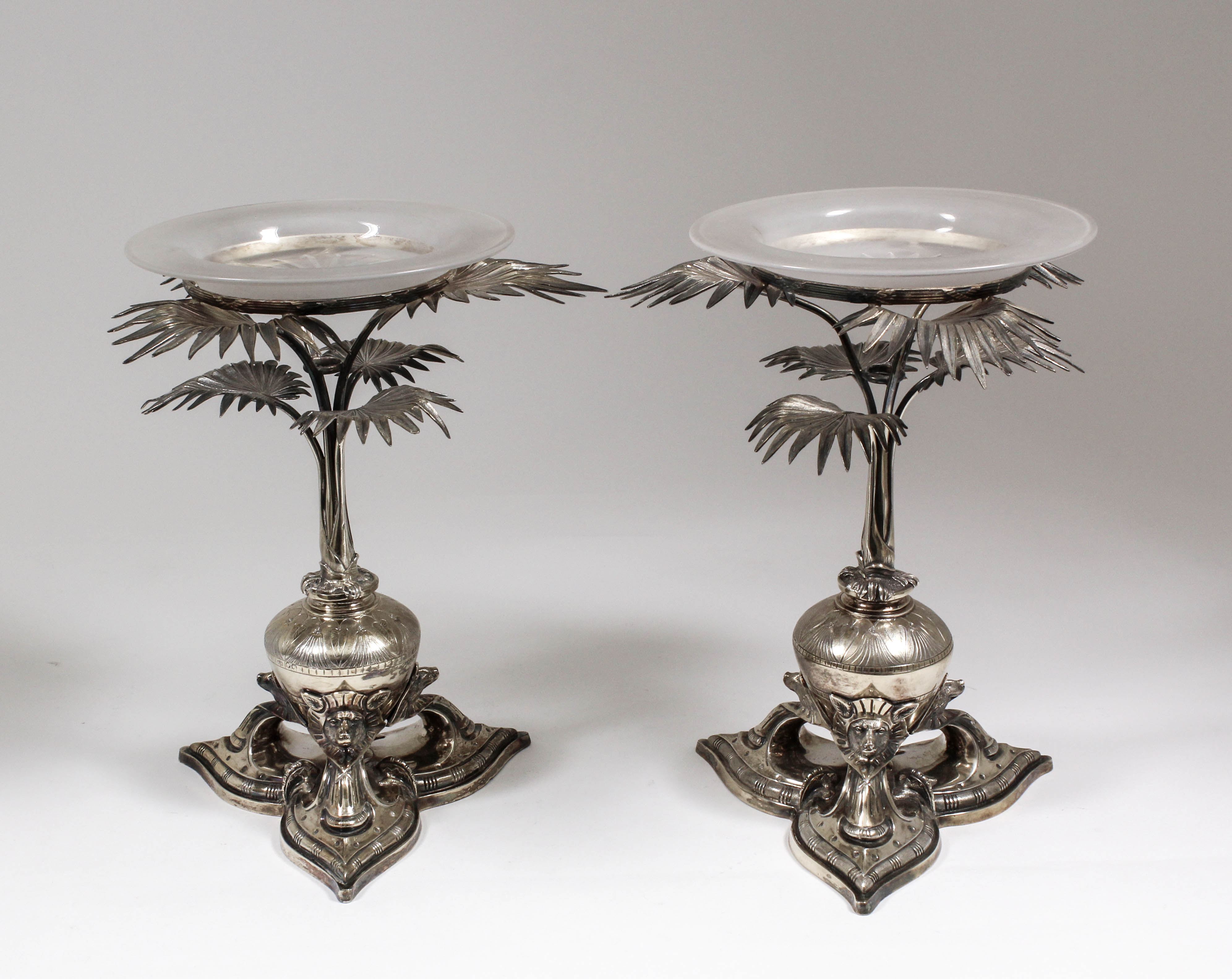 A pair of Victorian silver and parcel gilt table centres in the "Egyptianesque" manner, modelled