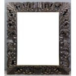 A Victorian carved oak framed rectangular wall mirror, the deep frame fretted and carved with scroll