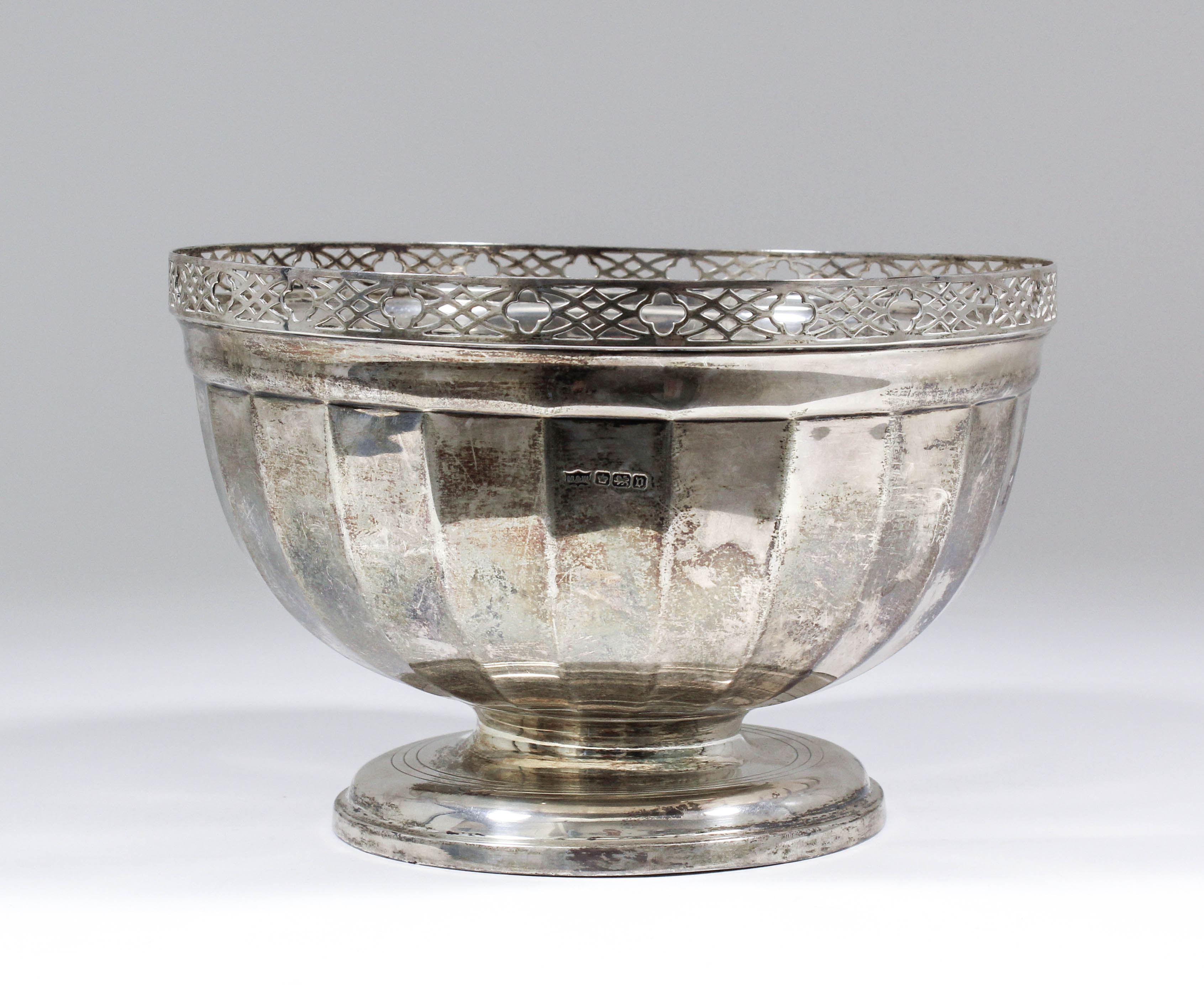 A George V silver circular bowl with pierced rim and panelled body on circular footrim, 8.75ins