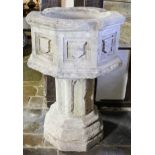 A late 15th Century English limestone octagonal font, the exterior with raised shield shaped panels,