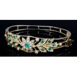 A late Victorian gold coloured metal mounted emerald and seed pearl set stiff pattern bracelet,