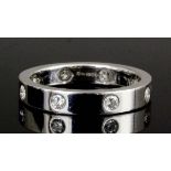 A modern 18ct white gold diamond set eternity ring in the "Cartier" manner, the plain band set