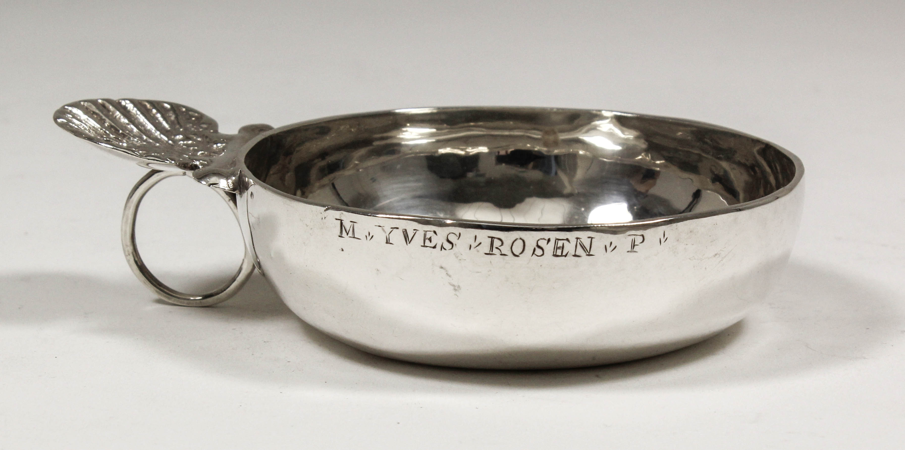 An 18th Century French plain silver circular taste-vin with cast shell and circular ring pattern