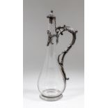 A late Victorian silver mounted liqueur decanter with plain glass bulbous body, the silver scroll