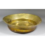 A large late 17th/early 18th Century brass bowl with turned-over rim, 19.5ins diameter x 4.25ins