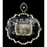 A gold coloured metal, black enamel and seed pearl set oval pattern mourning pendant with glazed