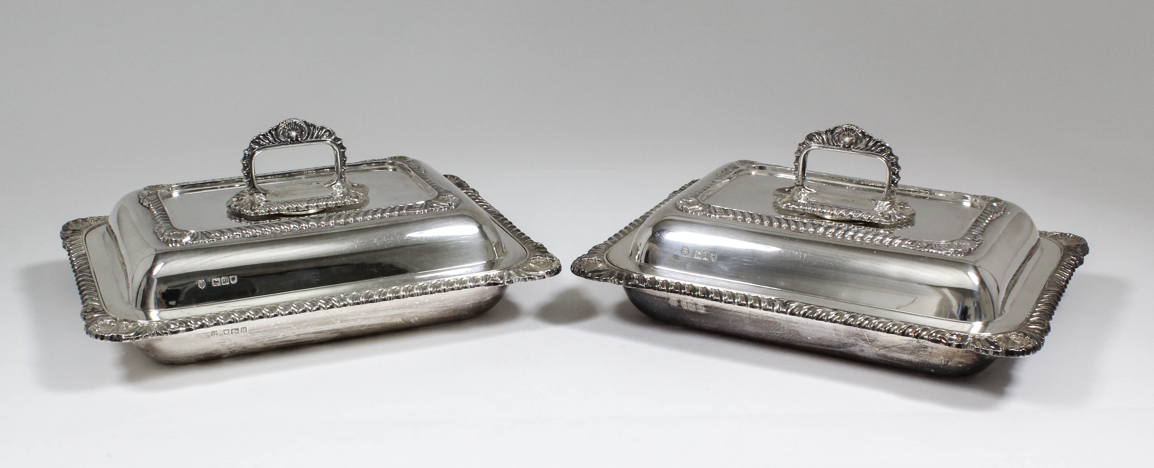 A pair of George V silver rectangular entree dishes and covers with bold gadroon, shell and leaf