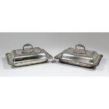 A pair of George V silver rectangular entree dishes and covers with bold gadroon, shell and leaf