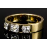 A 1920s gold coloured metal and diamond set three stone ring,the old cut stones each