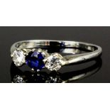 A modern 18ct white gold mounted sapphire and diamond three stone ring, the central circular cut