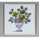 An 18th Century English Delft polychrome tile painted in Fazakerly colours of a vase of flowers,