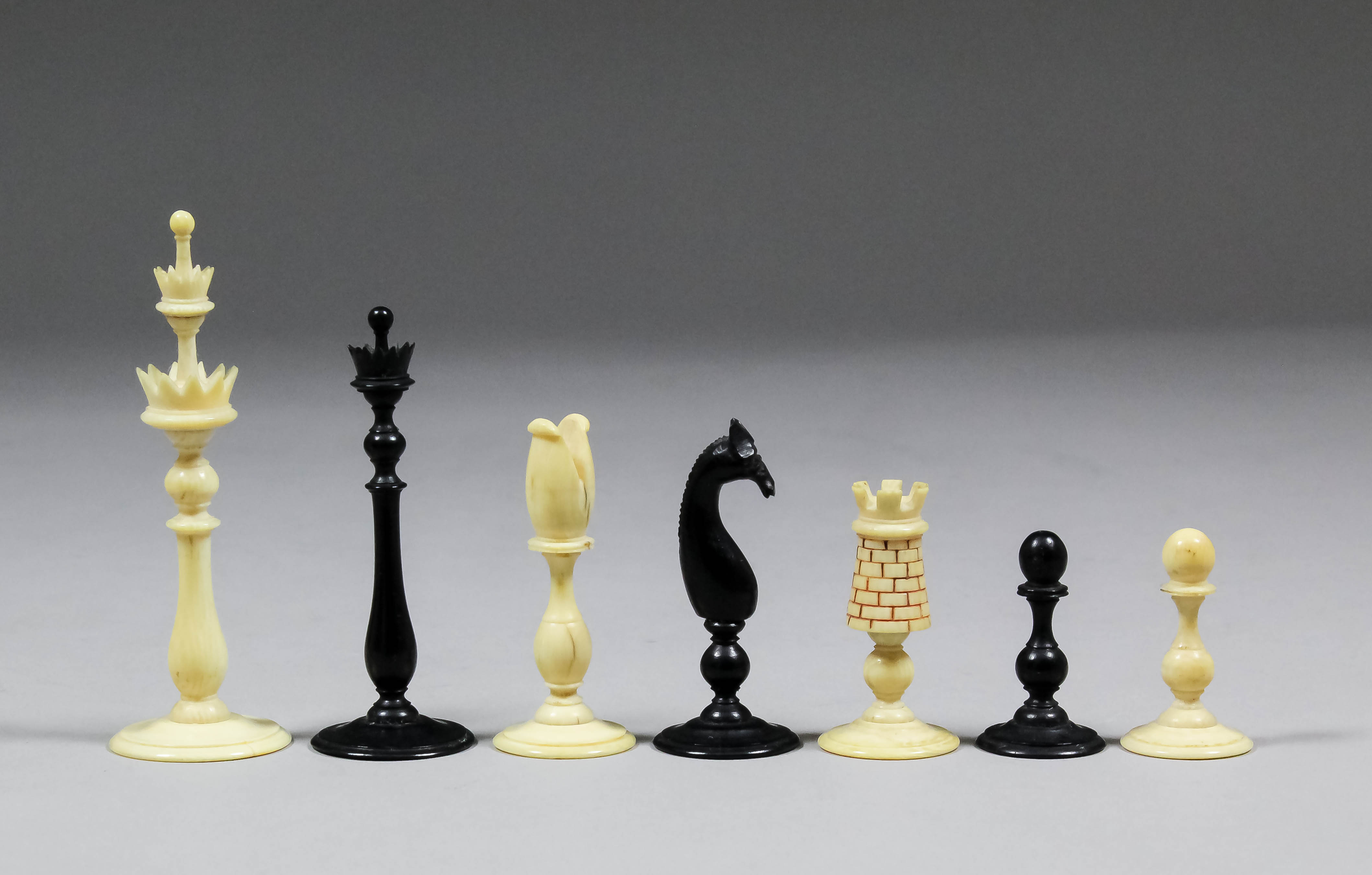 An 18th Century English black stained and plain turned ivory "Birds Nest" pattern chess set,