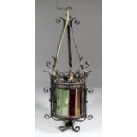 A wrought iron and pressed steel and coloured glass hall light, 21ins high