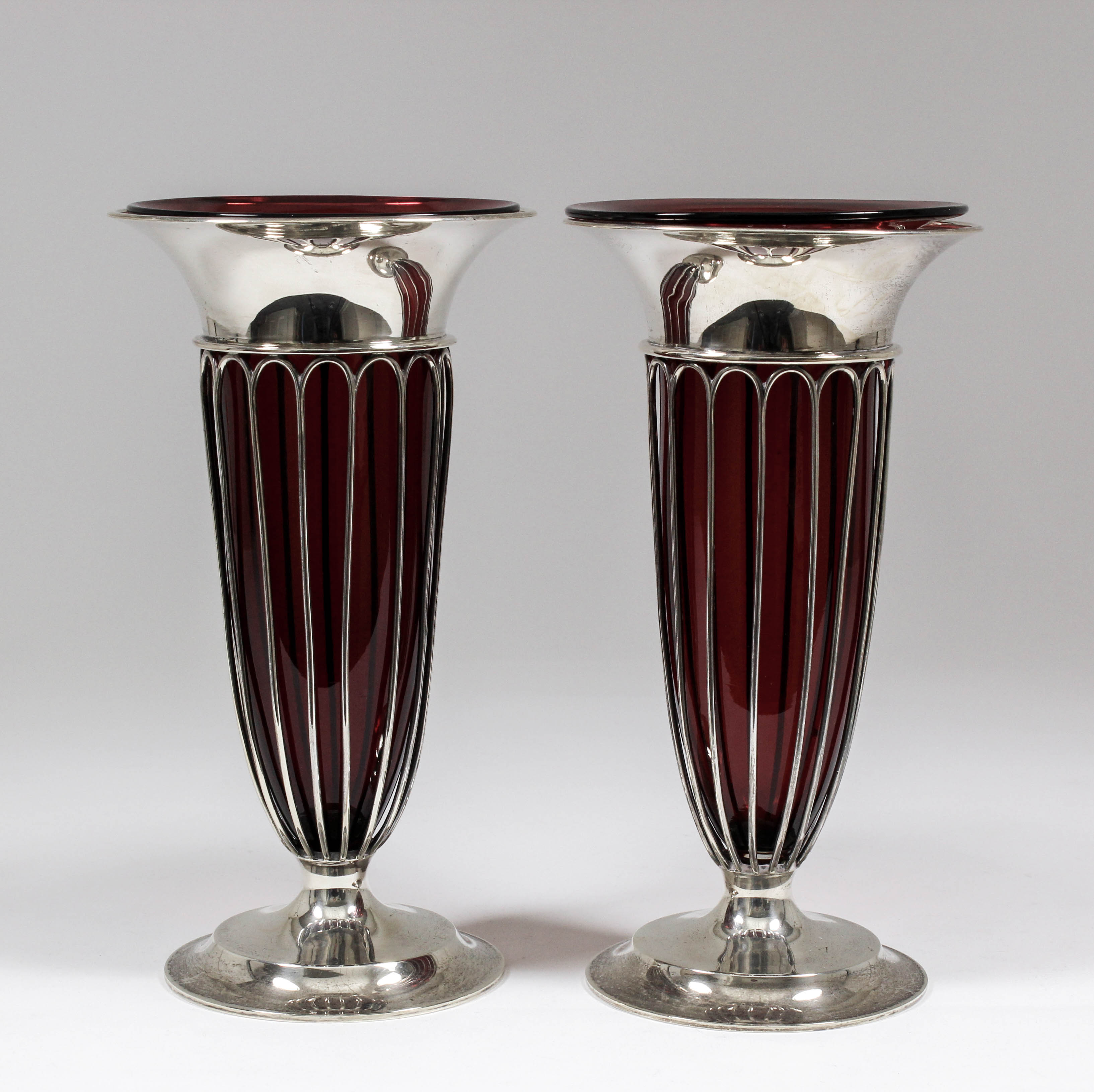 A pair of George V silver vases with plain flared rims and wirework bodies and plain moulded