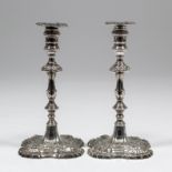 A pair of early George III cast silver pillar taper sticks, the square knopped columns with cast