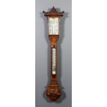 A late Victorian oak cased stick barometer and thermometer with white opaque glass scales and