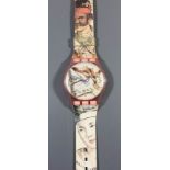 A large Swatch "Maxi-Masquerade" wall mounted wristwatch, decorated with masked figures, the 10.5ins