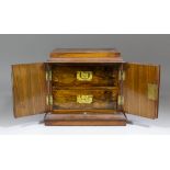 An early 20th Century walnut two drawer cigarette/tobacco cabinet enclosed by a pair of doors, 11ins