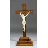 A 19th Century French carved ivory Corpus Christi mounted on oak crucifix and with stepped oak