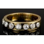 A 1920s gold coloured metal and all diamond set half hoop eternity ring, the face with eight