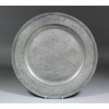 A 17th Century pewter dish, the centre with wrigglework decoration of a flower in full bloom with