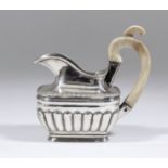 An early 19th Century Russian silvery metal milk jug with gadroon mounts to rim and partly reeded