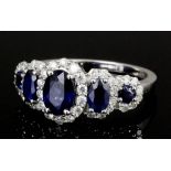 A modern 14k white gold mounted sapphire and diamond five stone ring, the central oval sapphire .