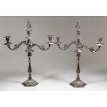 A pair of plated pillar candlesticks with two branch candelabra fitments, the candlesticks with