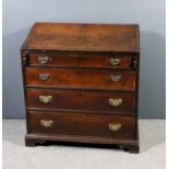 A late Georgian oak bureau, the slope enclosing seven small drawers, fitted four long graduated