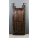 A 16th Century Northern European panelled oak door, each panel chip carved, 67ins x 25.5ins set into