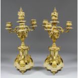 A pair of late 19th Century French gilt brass and white marble four light candelabra of Louis XVI