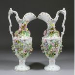 A pair of 19th Century Coalbrookdale porcelain flower encrusted ewers, 13.5ins high