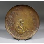 A late 19th/early 20th Century Japanese bronze circular dish cast with a seated monkey and its