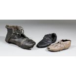 A Tudor leather shoe, 8.5ins long, complete with leather laces, a smaller example, 5.25ins long, and