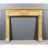 A 20th Century stripped pine fire surround of Neo-classical design with moulded dentil cornice,