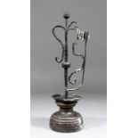 A 17th Century French wrought iron candlestick surmounted by an acorn knop, on turned fruitwood