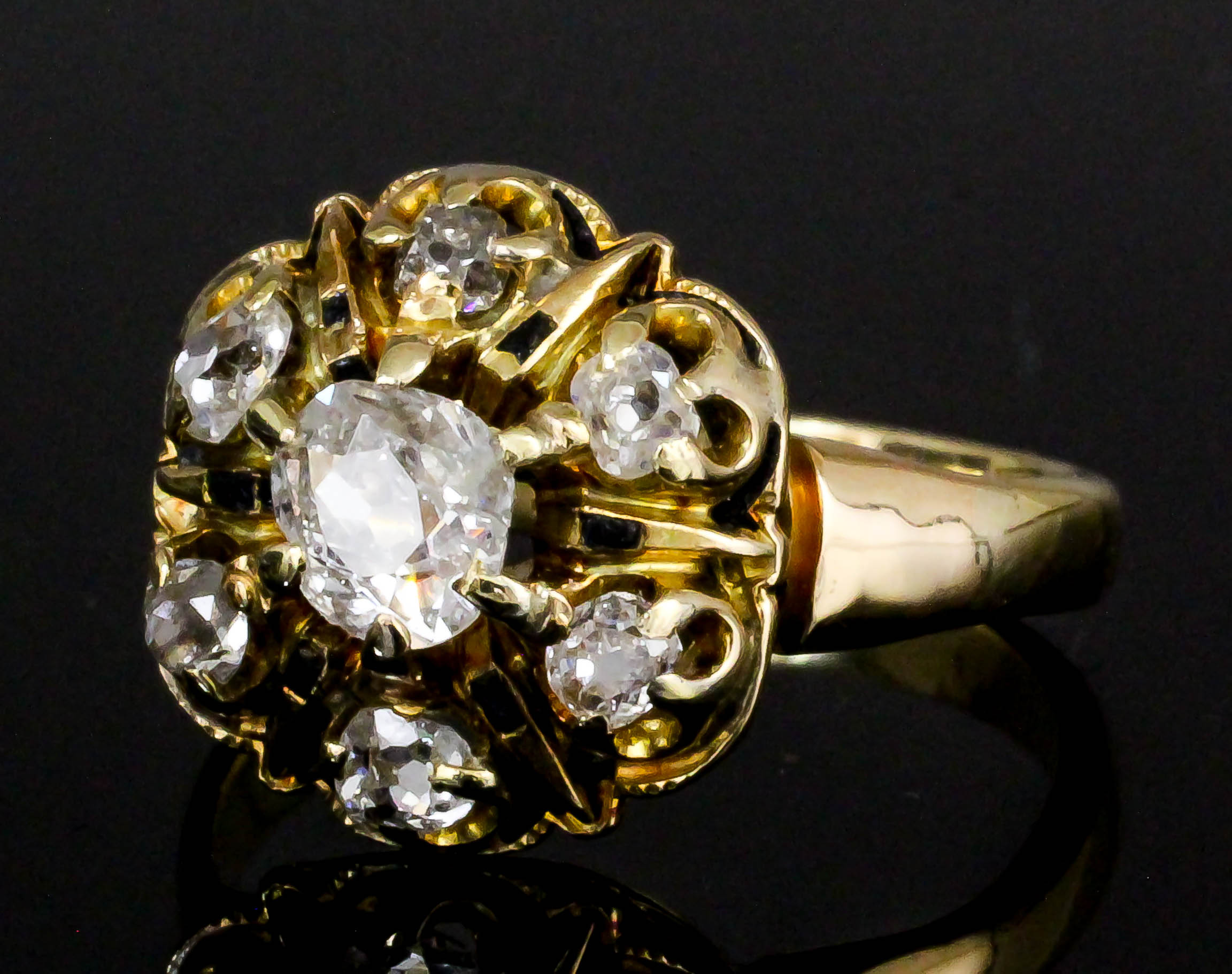 A late Victorian gold coloured metal mounted diamond and enamel set mourning ring, the central old