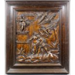 A 16th Century carved walnut panel with a classical scene of male and female figures beside a statue