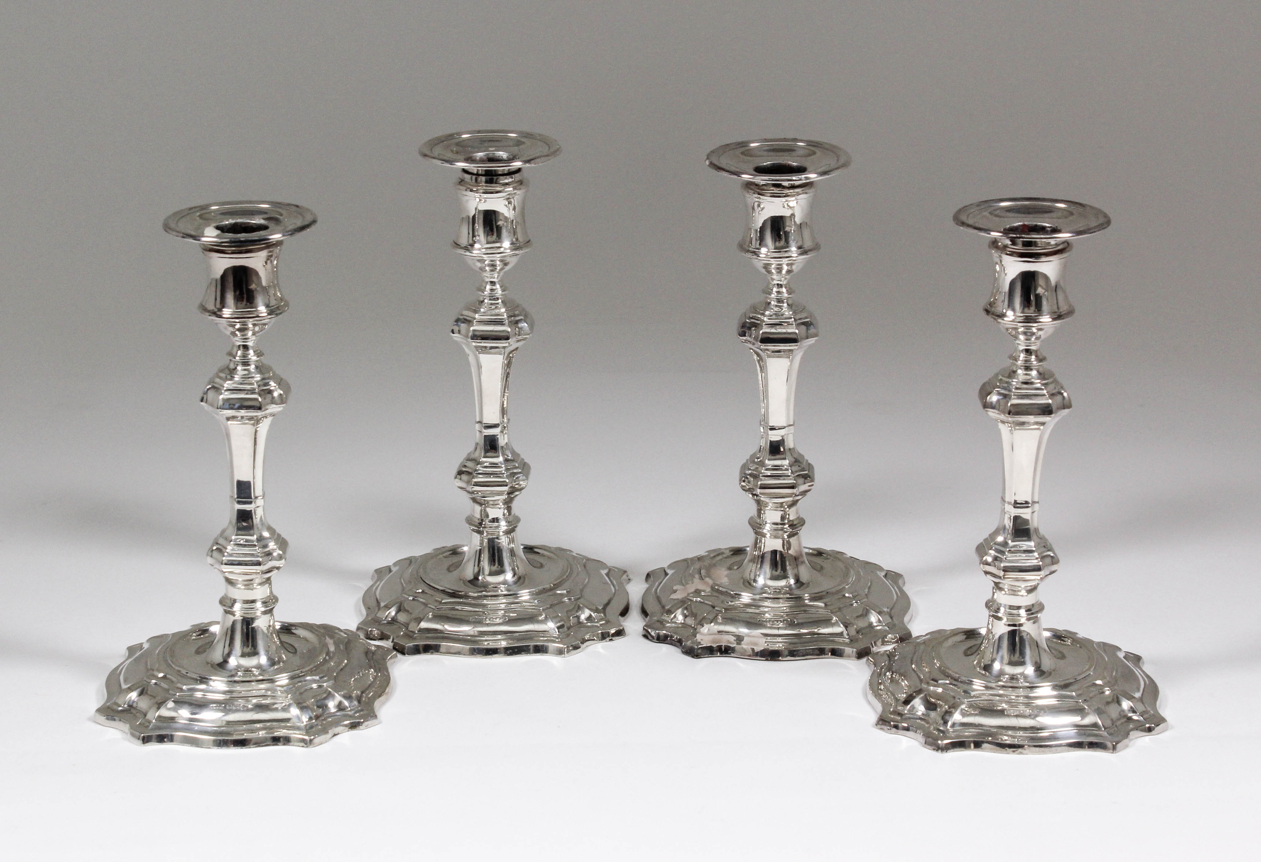 A set of four Elizabeth II silver pillar candlesticks of 18th Century design, with octagonal knopped