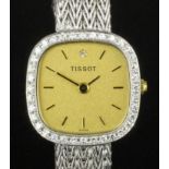 A modern lady's 15ct white gold cased Tissot wristwatch, the gilt dial with baton numerals,