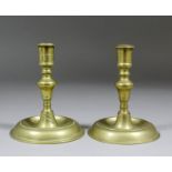 A pair of late 17th Century brass candlesticks, each shaft with pronounced knop above a shallow