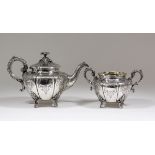 A Victorian silver circular teapot of bulbous panelled form, the whole engraved with scroll and