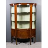 An Edwardian mahogany display cabinet of shaped outline, inlaid with satinwood bandings and