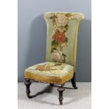 A Victorian mahogany framed Prie Dieu upholstered in floral needlework, on turned reeded and