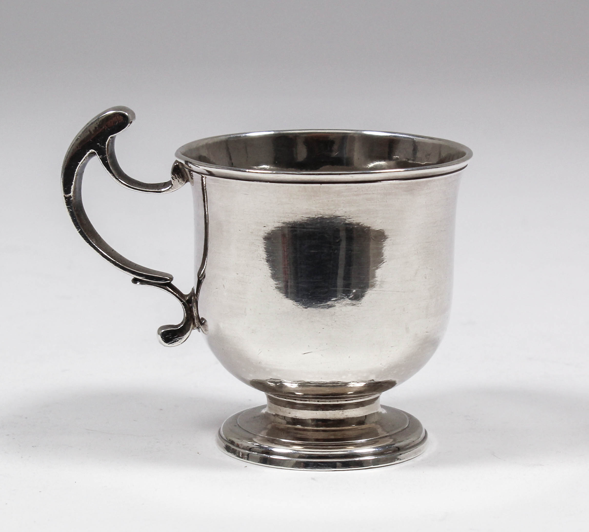 A George II plain silver urn shaped tot or mug with open double scroll handle and moulded rim and