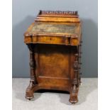 A Victorian figured walnut Davenport of shaped outline, the superstructure with galleried stationary