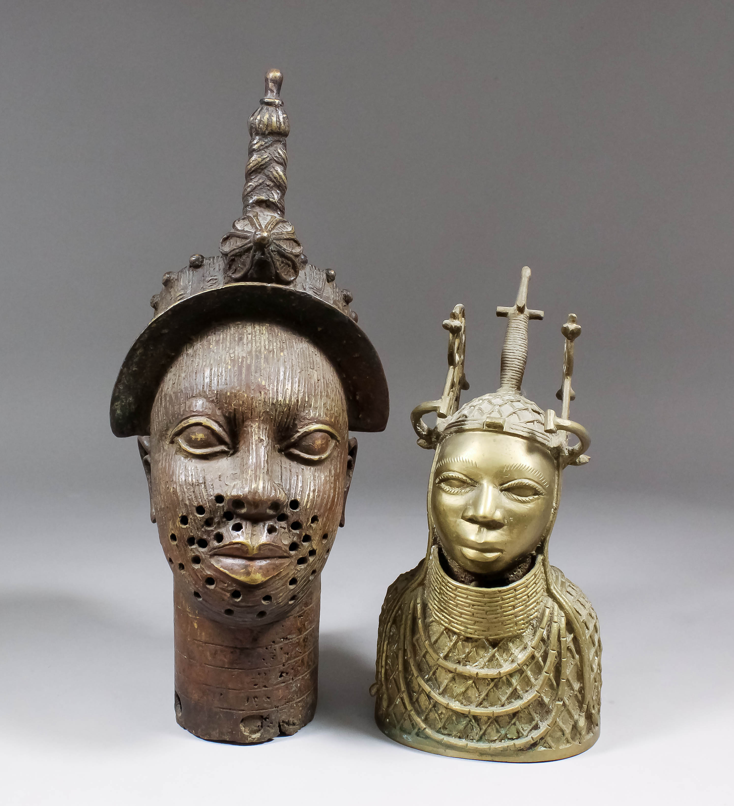 A Benin cast brass head of a male with scarification marks to his face and ornate headpiece, 16ins